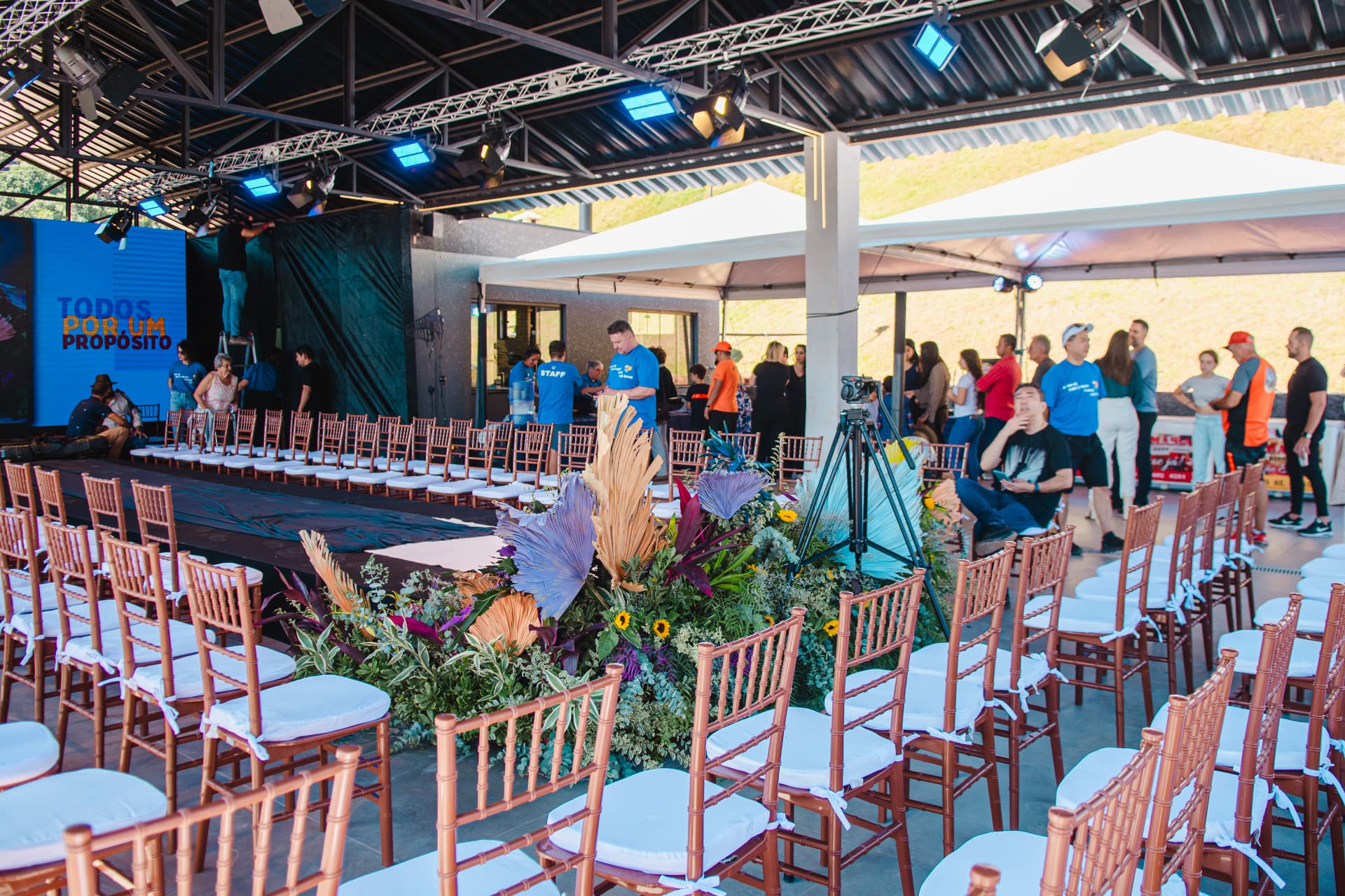 Estrutura do evento montada com passarela, cadeiras e decoração floral